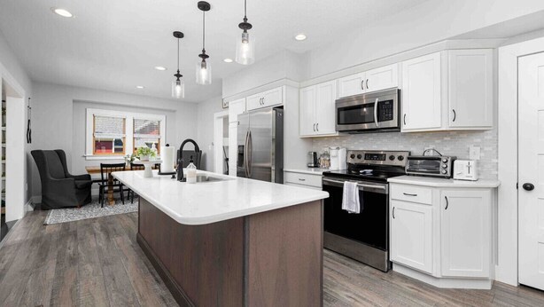 A modern kitchen with white cabinets, stainless steel appliances, and a central island. - Best Location, Renovated, Walk Uptown! - 3br/3ba (Perrysburg)