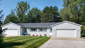 A two-story house with a front garage, a covered porch, and a well-maintained lawn.