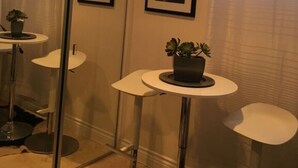 Une salle de bain avec une douche à parois de verre, des toilettes, un lavabo avec un miroir et deux tableaux encadrés au mur.
