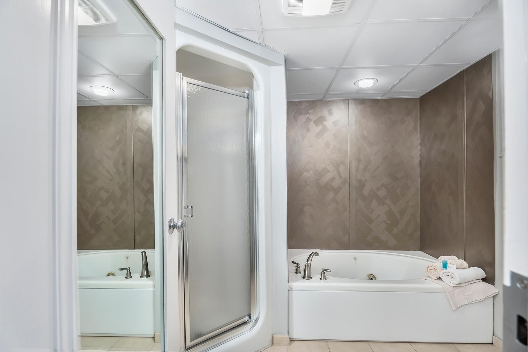 A modern bathroom with a glass-enclosed shower, a freestanding bathtub, and a vanity with a mirror.