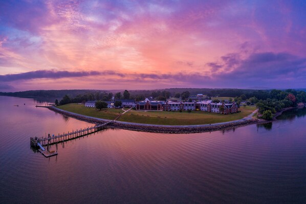 A lakeside property with a dock, a large building with multiple wings, and a well-maintained lawn. - Spectacular Top Floor Deluxe Suite With Beautiful View & More! (North East)