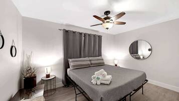 2 habitaciones, escritorio y tabla de planchar con plancha