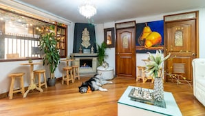 Una sala de estar acogedora con chimenea, muebles de madera y un perro acostado en el suelo.