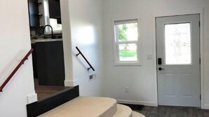 A staircase leading to a landing with a door and windows.