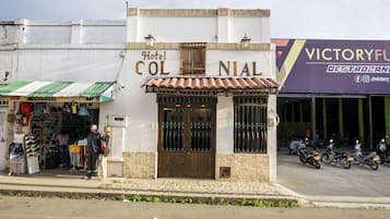 Hotel Col Nial, con un acceso con baldosas y un escaparate con varios artículos a la venta.