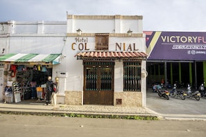 Hotel Col Nial, com entrada em azulejos e vitrine com diversos artigos à venda.