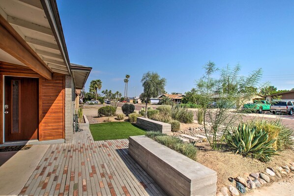 A modern house with a brick patio, a well-maintained lawn, and a variety of desert plants. - Fire Pit, Heated Pool: Central Tempe Escape! (Tempe)