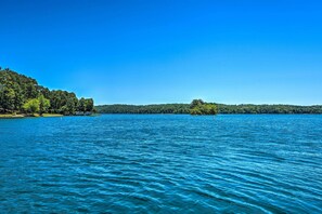 A calm lake with a forested shoreline and a small island in the distance. - Resort-Style Condo w/ Balcony on Lake Keowee (Salem)
