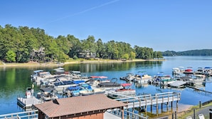 A marina with various boats docked, surrounded by a forested shoreline. - Resort-Style Condo w/ Balcony on Lake Keowee (Salem)