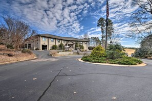A two-story building with a garage, surrounded by trees and a clear sky. - Resort-Style Condo w/ Balcony on Lake Keowee (Salem)