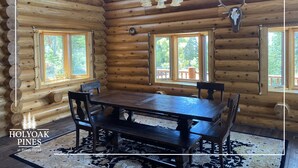 A log cabin interior with a wooden dining table, chairs, and a chandelier. - Views Galore, Spacious Luxury (Brian Head)