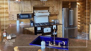 A kitchen with wooden cabinets, a stainless steel refrigerator, a stove, and pendant lights. - Views Galore, Spacious Luxury (Brian Head)