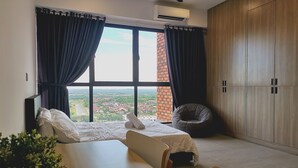 A bedroom with a large window, a bed, a chair, and a wardrobe. - Bell Suite Sepang KLIA Kota Warisan (Sepang)
