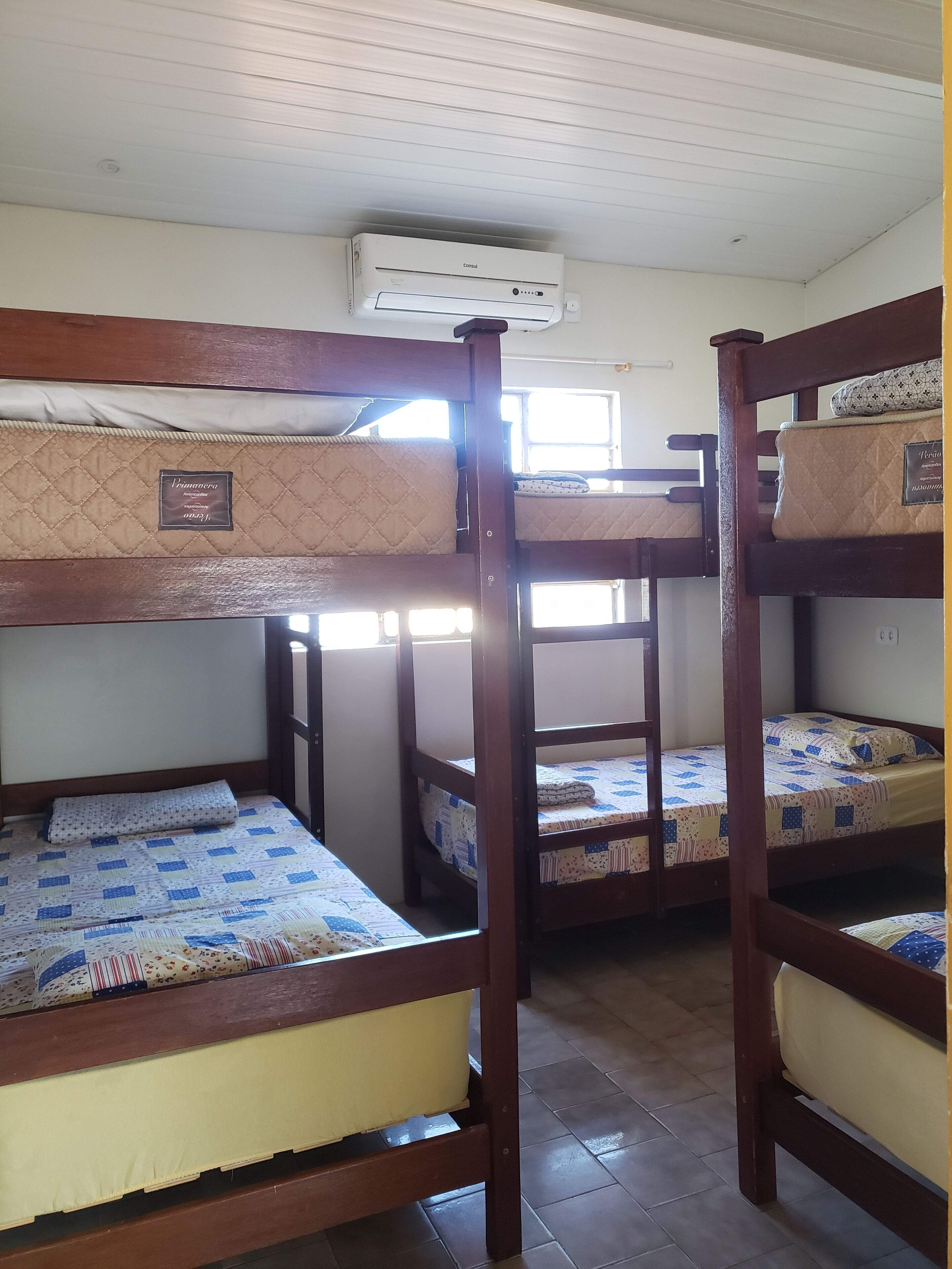 Una habitación con literas, ventana y aire acondicionado.