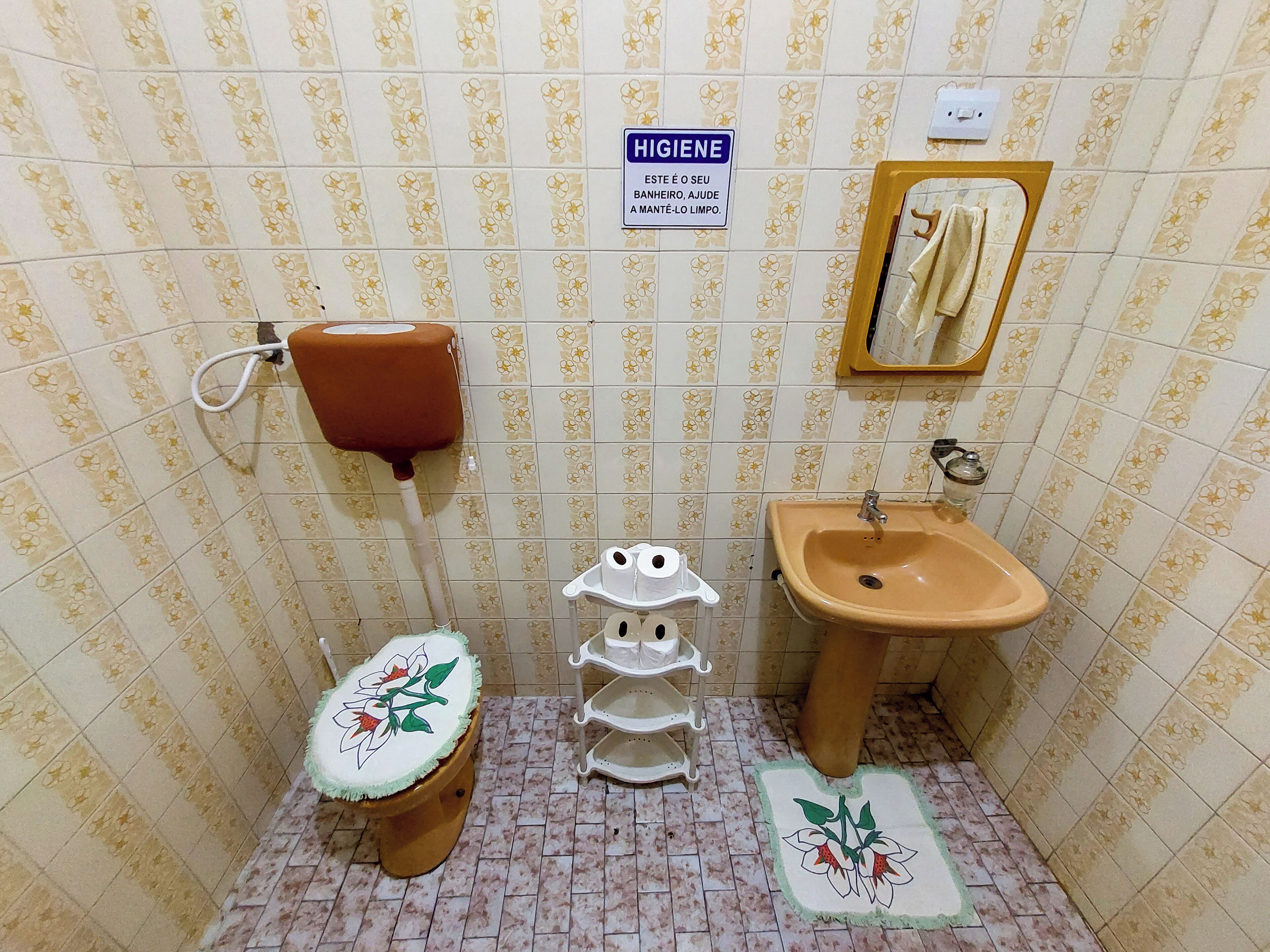 A bathroom with a toilet, sink, and hand dryer.