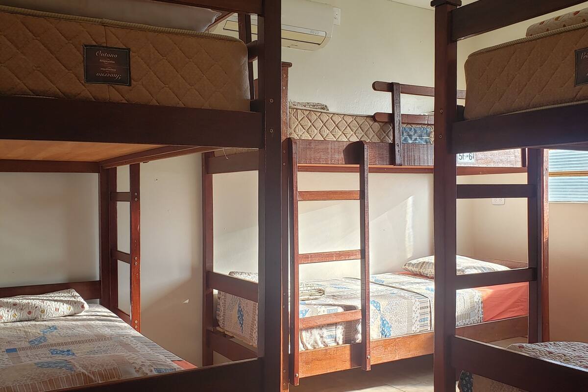 Bunk beds in a room with a tiled floor and a ceiling with wooden beams.