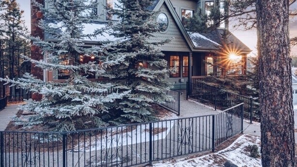 A large, two-story house with a prominent turret and a snow-covered landscape. - PARADISE! Family Reunions, Business Retreats, Vacations (Flagstaff)