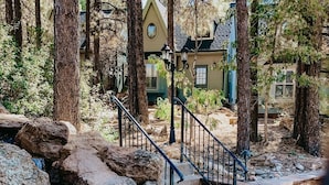 A natural outdoor area with a small waterfall, stone steps, and a metal railing. - PARADISE! Family Reunions, Business Retreats, Vacations (Flagstaff)