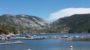 A marina with boats docked, surrounded by mountains and forested hills. - Cabin in the Pines, 3BR, Arcade Room, Wraparound Deck, Walk to Town, Dogs OK (Twain Harte)