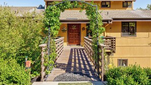 A wooden house with a covered walkway leading to a wooden door. - Yosemite Lodge • Indoor pickleball, Basketball, Hot Tub, Game Room & EV (Oakhurst)