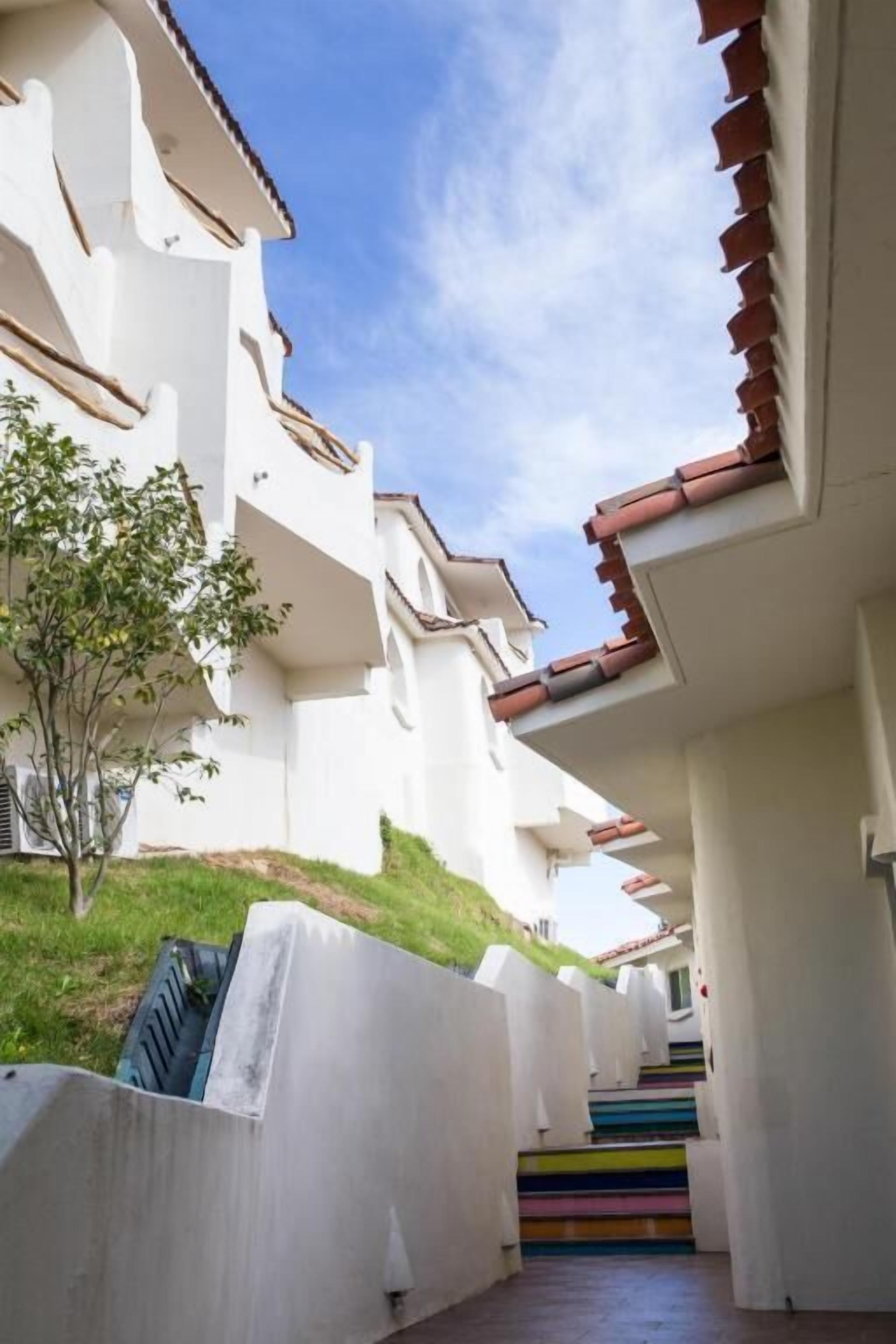 A white building with a staircase leading to a colorful landing.