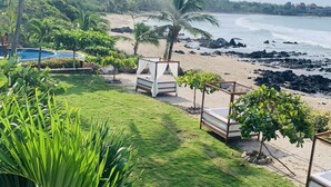 Une chambre avec vue sur la plage, dotée d’un lit et d’une piscine.