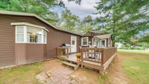A two-story cabin with a porch, a grill, and a small garden area. - Walk to Beach & Lake: Idyllic Escape in Edinboro! (Edinboro)