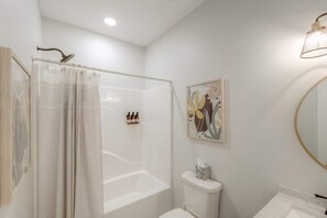 Ein modernes Badezimmer mit Duschkabine aus Glas, Toilette und Waschbecken.