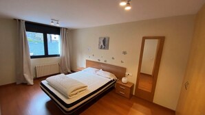 Une chambre à coucher avec un lit, une table de chevet et une fenêtre avec des rideaux.