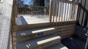 A wooden deck with steps leading to a house.