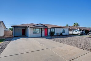 A single-story house with a red door, a garage, and a driveway. - Relax Poolside: Central Group Getaway in Mesa! (Mesa)