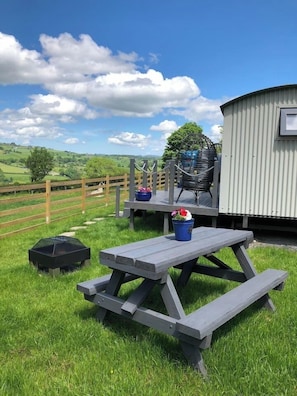 Enjoy a peaceful meal at this outdoor setting with a picnic table, grill, and comfortable seating.