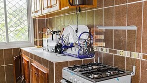 Una cocina con muebles de madera, estufa a gas y microondas.