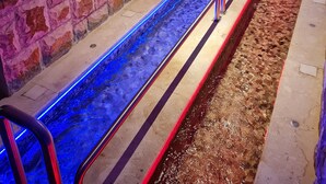A spa area with a stone wall, a long water channel, and a seating area with railings. - 2-Bedroom, Sleeps 4, Free Parking (Vlore)