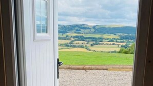 A view through a door with a landscape of rolling hills and fields. - Woodhead Shepherds Hut - Sleeps 2 - Parking (Perth)