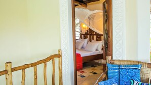 Une chambre à coucher avec un lit en bois, une couverture rouge et un baldaquin.