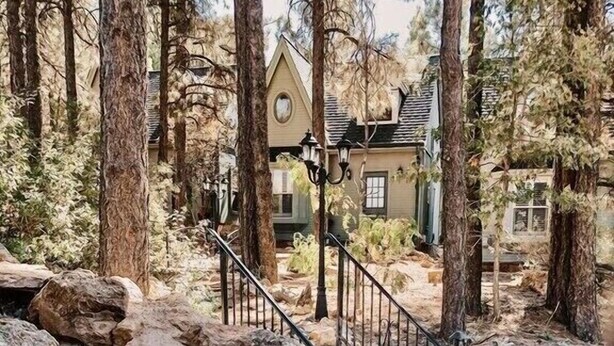 Una escalera de piedra que lleva a una casa rodeada de árboles.