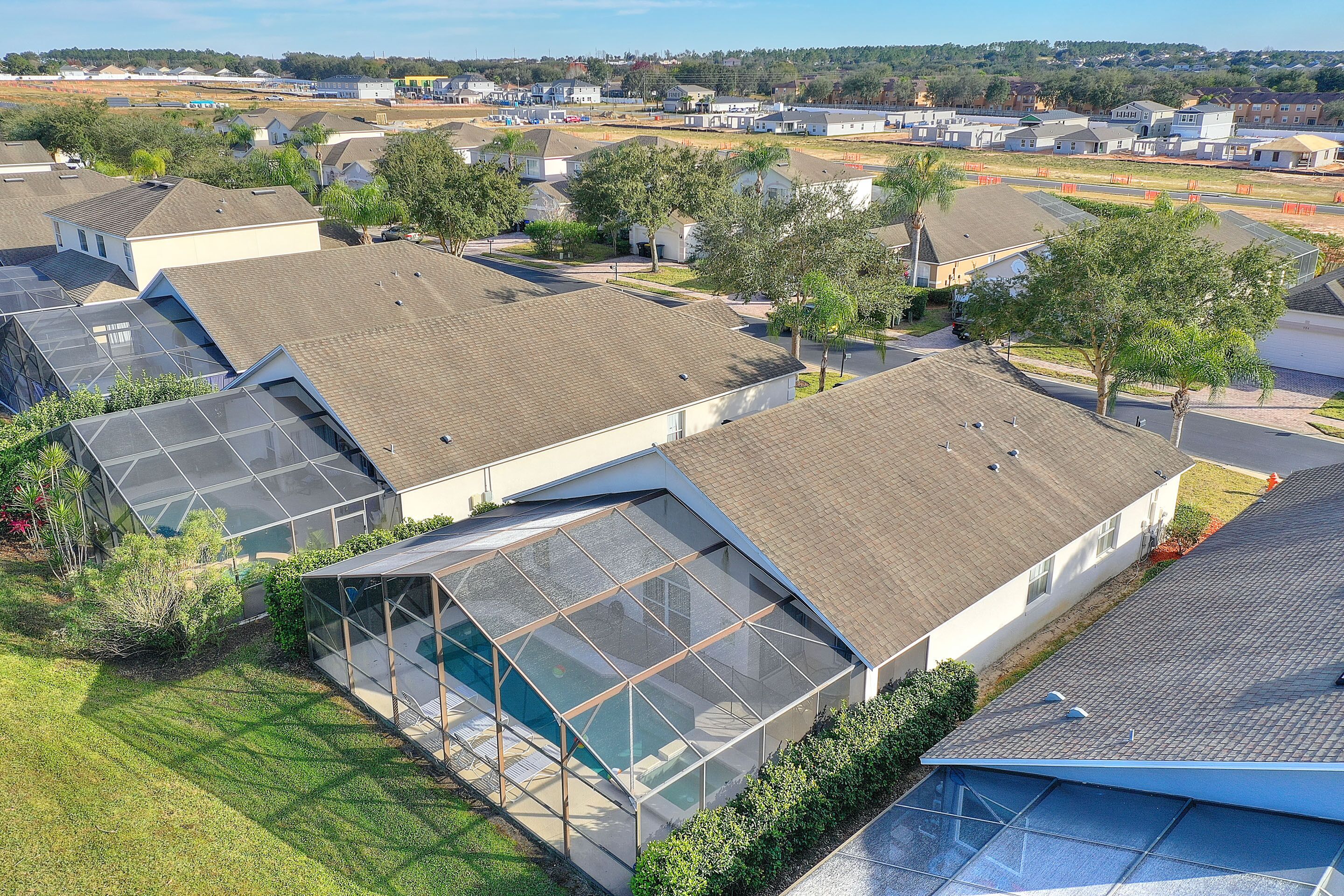 Ett bostadsområde med moderna hus som har stora glasfönster och solpaneler.