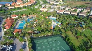 Ein Luftbild eines Wohngebiets mit Häusern, einem Schwimmbad, Tennisplätzen und einem Park.