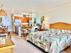 Una habitación con cama, una mesa de comedor con sillas, una zona de cocina y un baño.