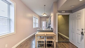 A hallway with a wooden floor, a white door, and a window with blinds. - Boston Apartment < 10 Mi to Top Universities (Revere)
