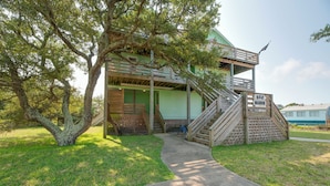 A two-story building with a wooden deck and a staircase leading to the upper level. - Quiet Hatteras Duplex with Decks ~ 1 Mile to Beach (Hatteras)