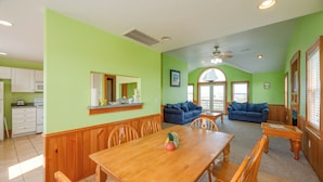 A spacious living area with a wooden dining table, two sofas, and a kitchen in the background. - Quiet Hatteras Duplex with Decks ~ 1 Mile to Beach (Hatteras)