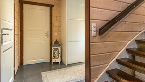 Un interno in legno con una scala, una porta bianca e un piccolo lanterne.