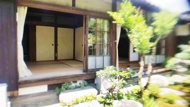 A traditional Japanese-style room with tatami flooring, sliding doors, and a small garden area with rocks and plants. - Tuwano sou (Tsuwano)