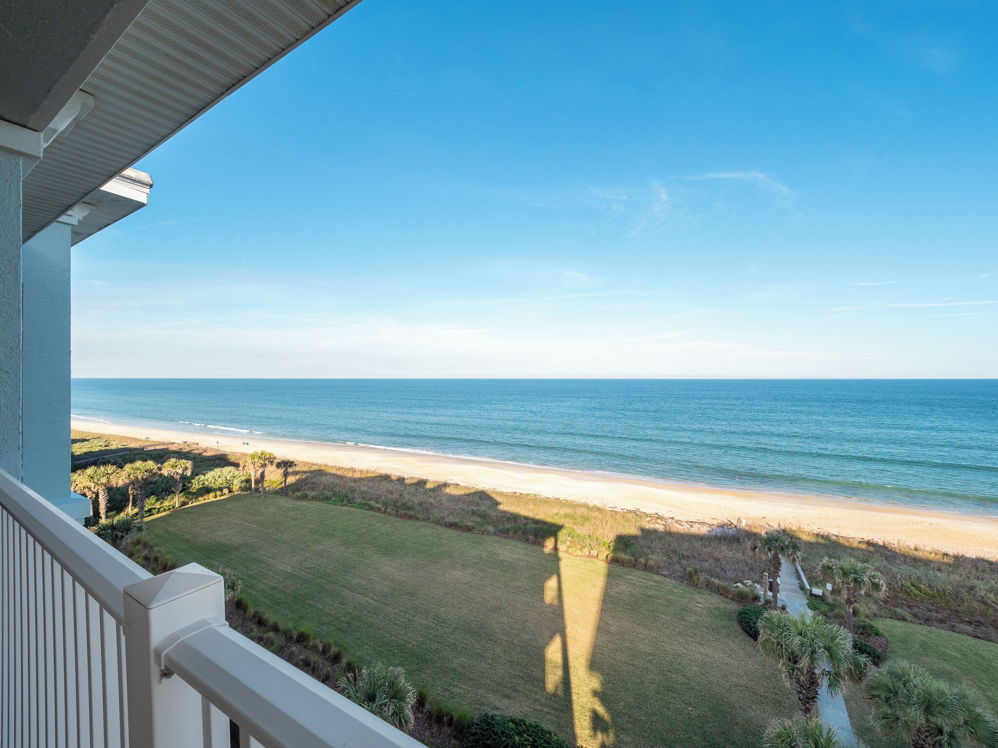 A balcony with a view of a beach and ocean.