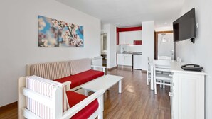 Een moderne woonkamer met een bank, een eettafel en een keuken op de achtergrond.