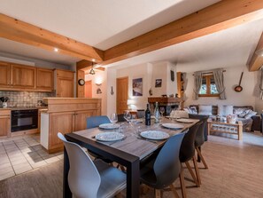 Eine moderne Küche mit Holzausstattung, einem Esstisch gedeckt mit Tellern, Gläsern und Besteck.