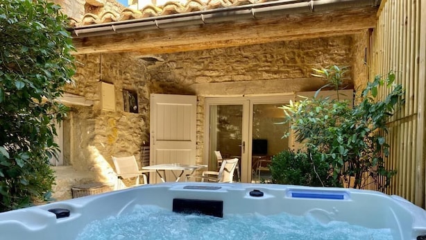 A stone building with a hot tub in the foreground. - CHAMBRE GRAND CONFORT COQUET with PRIVATE JACUZZI (Martignargues)