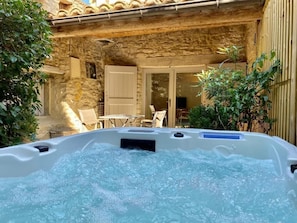 A stone building with a hot tub in the foreground. - CHAMBRE GRAND CONFORT COQUET with PRIVATE JACUZZI (Martignargues)